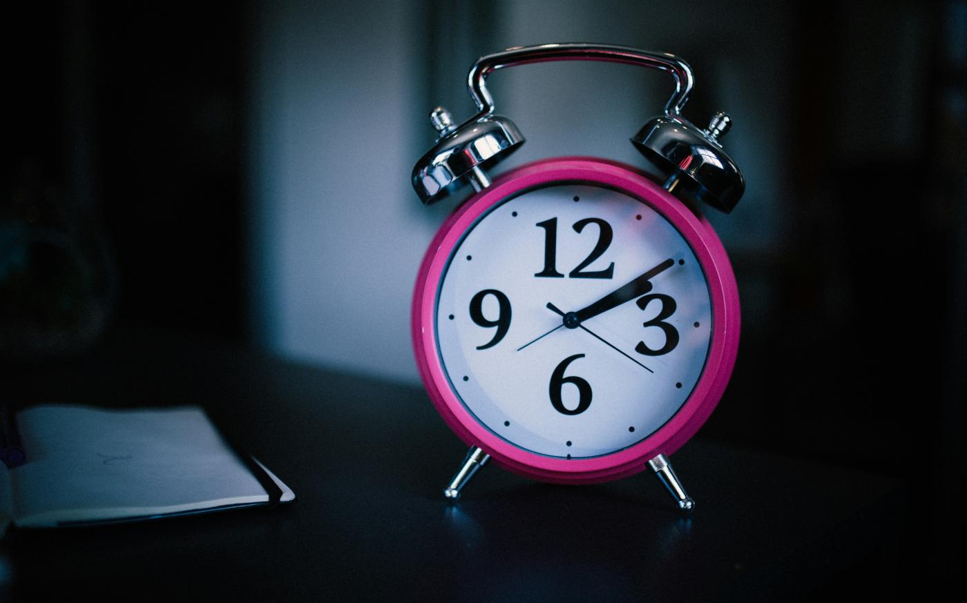 pink bell alarm clock showing 2:10 by Mpho Mojapelo courtesy of Unsplash.