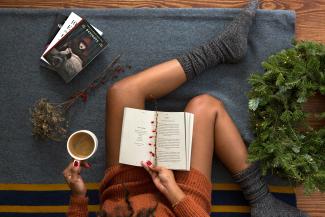 opened book on person's lap with gray socks by Thought Catalog courtesy of Unsplash.