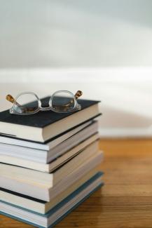 clear framed eyeglasses on top of pile of books by Kari Shea courtesy of Unsplash.