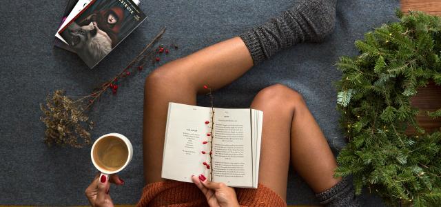 opened book on person's lap with gray socks by Thought Catalog courtesy of Unsplash.